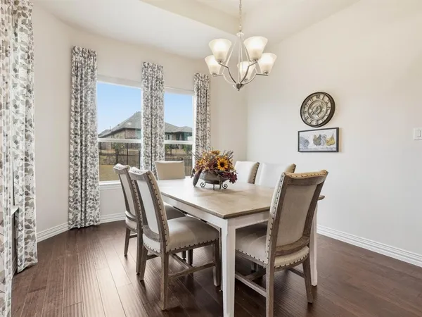 a view of a dining room with furniture wooden floor and chandelier
