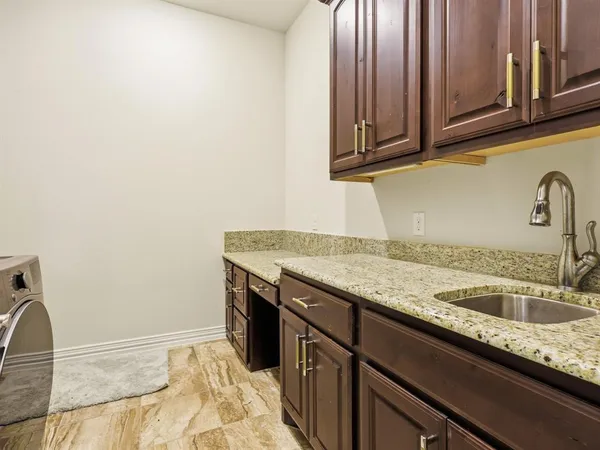 a kitchen with granite countertop a sink and cabinets