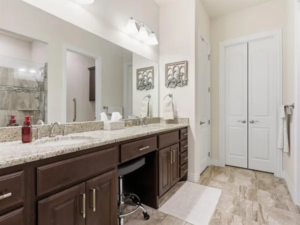 a bathroom with a granite countertop sink a mirror and a shower