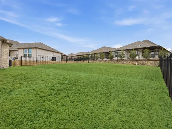 a view of a house with a big yard and large trees
