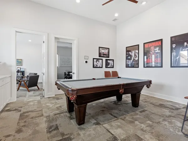 a room with furniture pool table and wall paintings