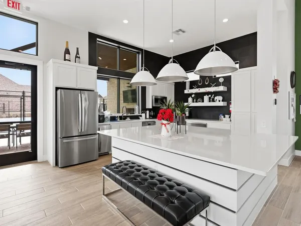 a kitchen with stainless steel appliances granite countertop a refrigerator and a stove top oven