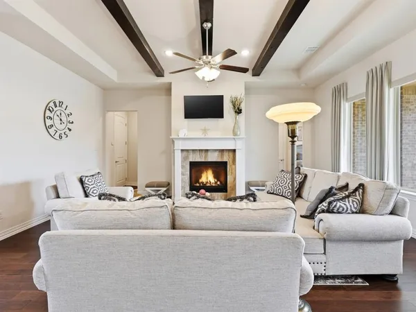 a living room with furniture a fireplace and a flat screen tv