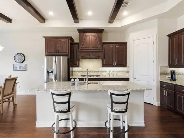 a kitchen with a table chairs refrigerator and cabinets