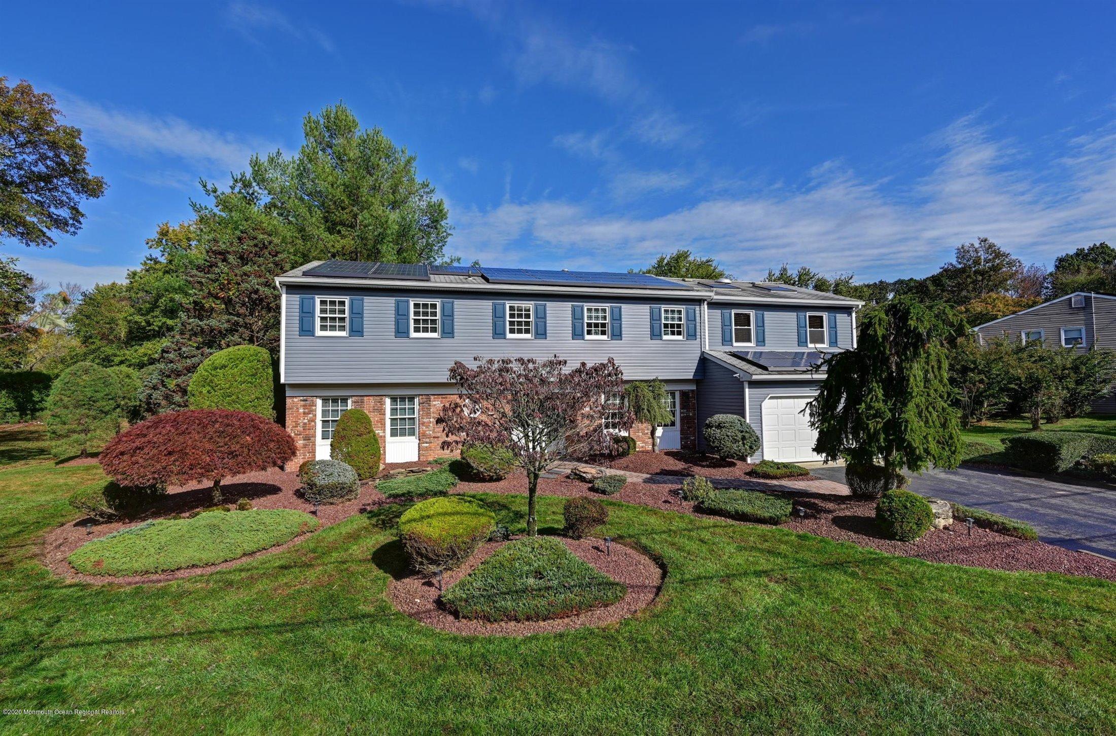 4 Canadian Woods Road Marlboro, NJ 07746 - Photo 2 of 33 a view of a house with a big yard and potted plants and large trees