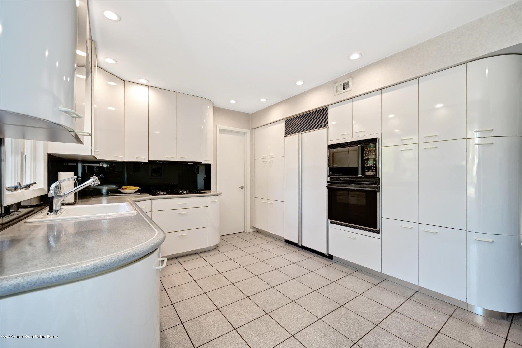 4 Canadian Woods Road Marlboro, NJ 07746 - Photo 11 of 33 a large white kitchen with a refrigerator a stove a sink and a microwave