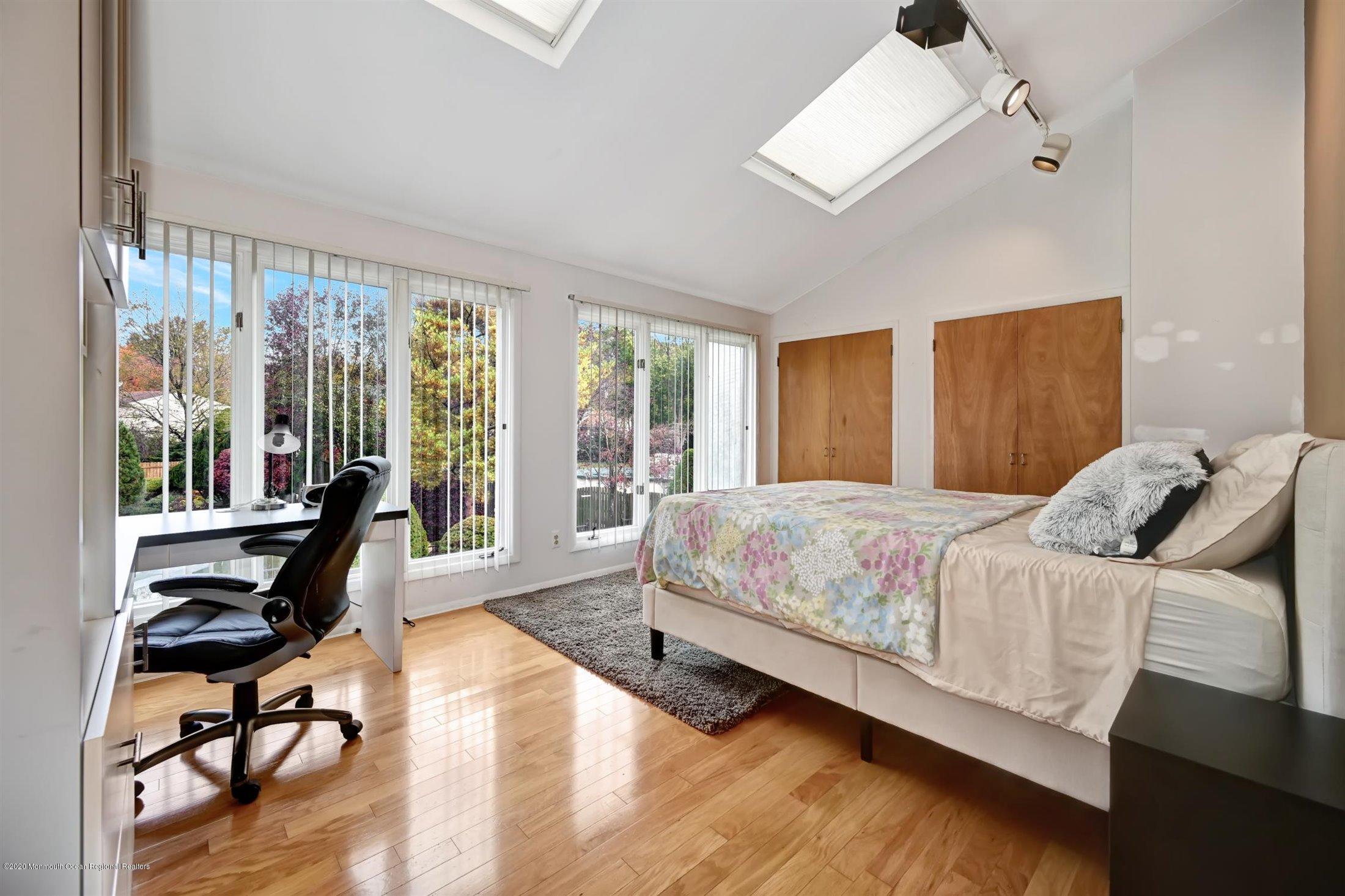 4 Canadian Woods Road Marlboro, NJ 07746 - Photo 19 of 33 a bedroom with a bed a desk and chair with wooden floor