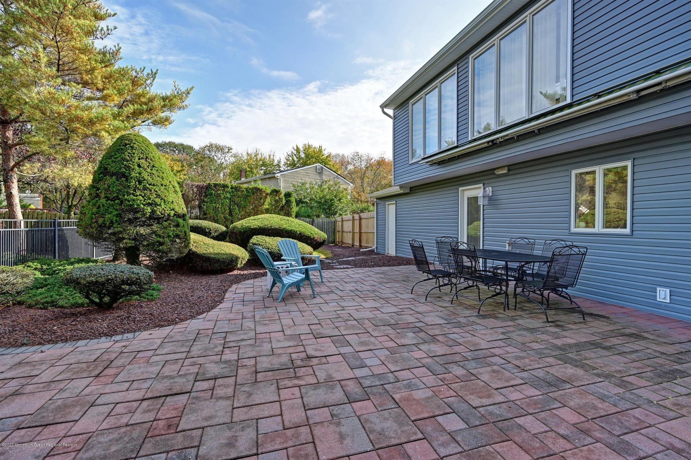4 Canadian Woods Road Marlboro, NJ 07746 - Photo 28 of 33 a view of a chairs and a table in backyard of the house