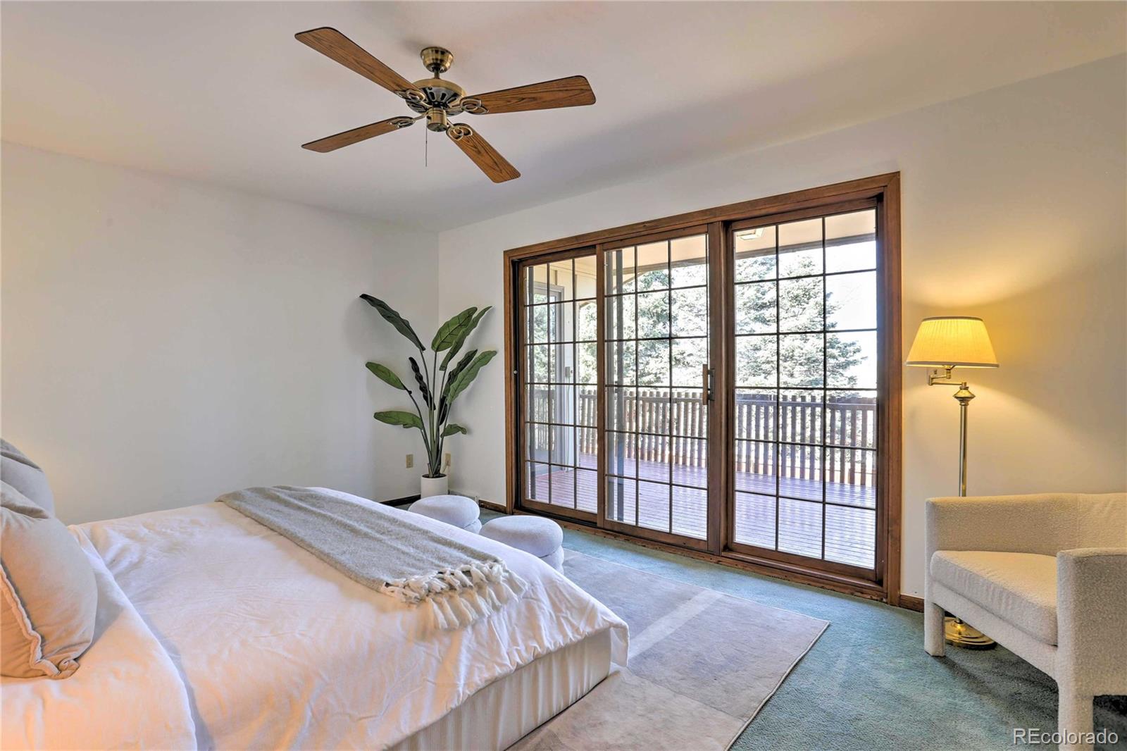4452 South Xeric Way Denver, CO 80237 - Photo 14 of 40 a bedroom with a large bed and a chandelier fan