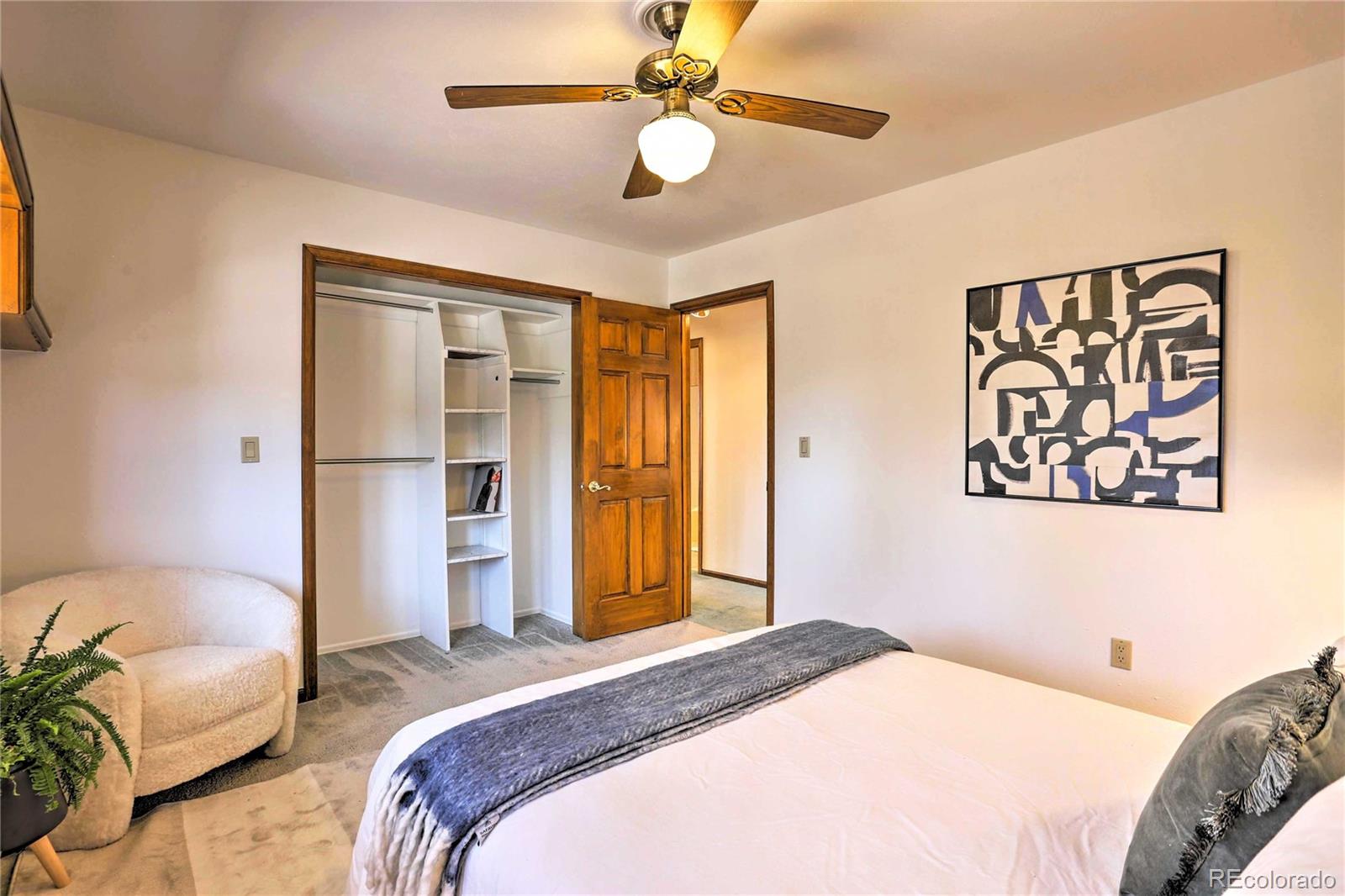 4452 South Xeric Way Denver, CO 80237 - Photo 22 of 40 a bedroom with a bed and a chandelier