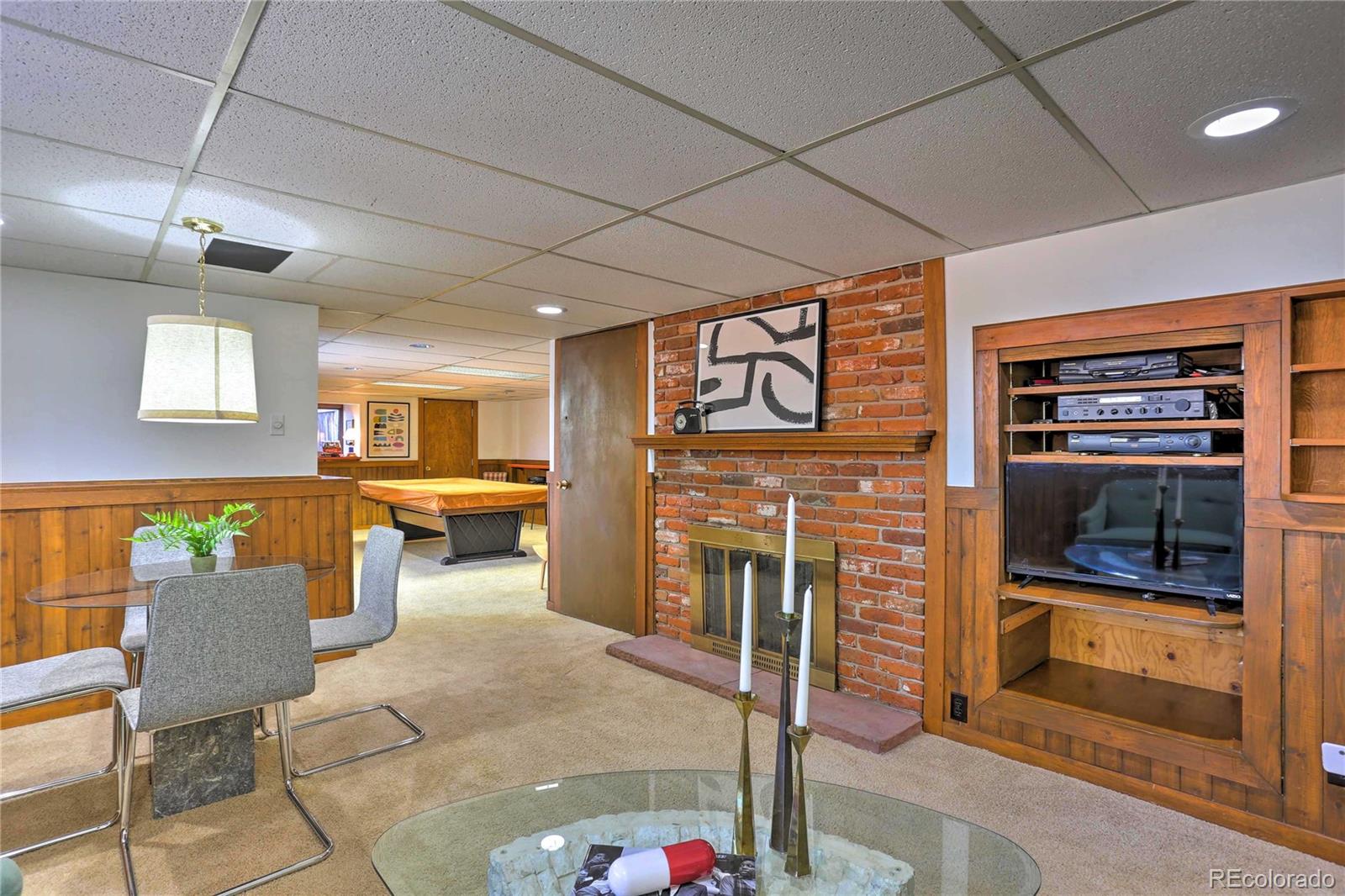 4452 South Xeric Way Denver, CO 80237 - Photo 30 of 40 a living room with furniture a flat screen tv and a fireplace