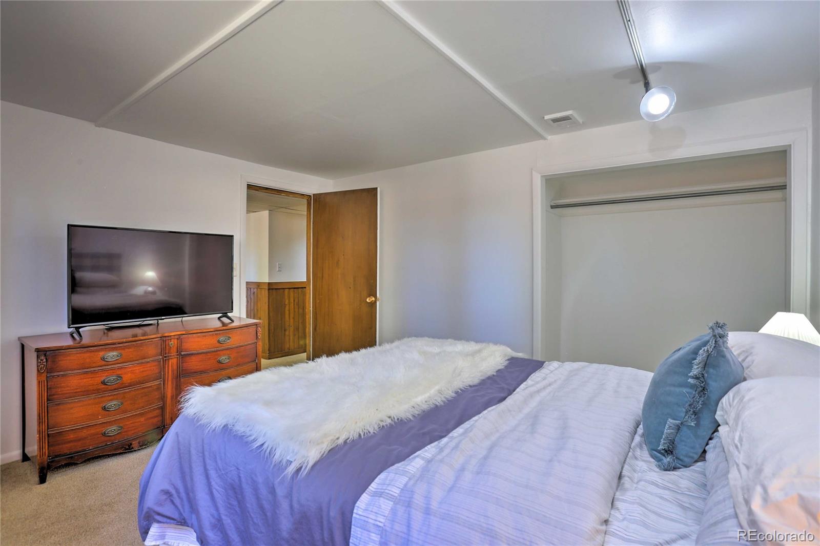 4452 South Xeric Way Denver, CO 80237 - Photo 34 of 40 a bedroom with a bed and a flat screen tv