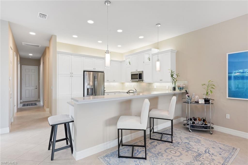13338 Coronado Drive Naples, FL 34109 - Photo 3 of 22 a kitchen with stainless steel appliances kitchen island granite countertop a sink and cabinets