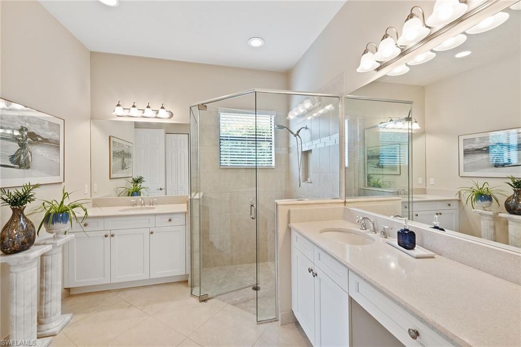 13338 Coronado Drive Naples, FL 34109 - Photo 7 of 22 a spacious bathroom with a sink a large mirror and a shower