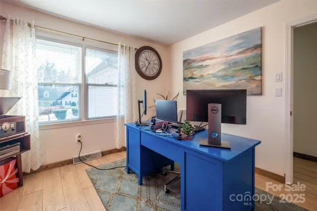 a view of a workspace with furniture and a window