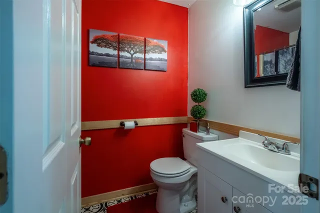 a bathroom with a toilet a sink and mirror