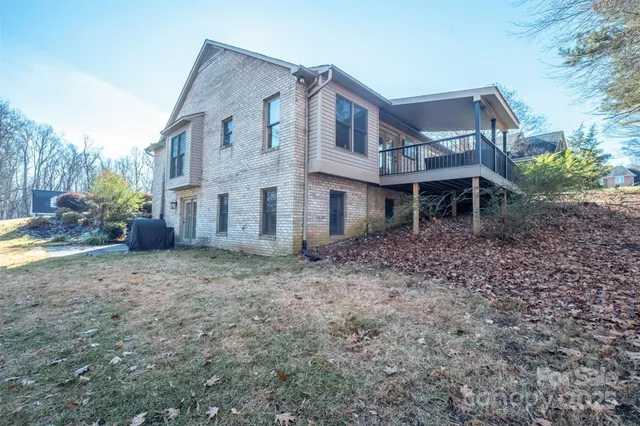 a view of a big house with a yard and large tree