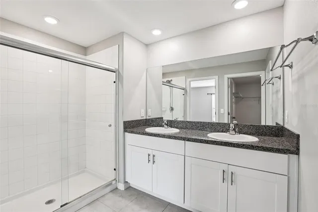 a bathroom with a granite countertop sink a mirror and a shower
