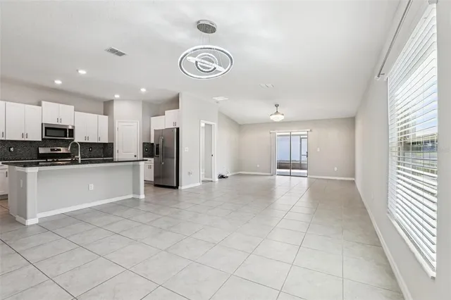 a view of a kitchen with a sink and dishwasher a refrigerator with white cabinets
