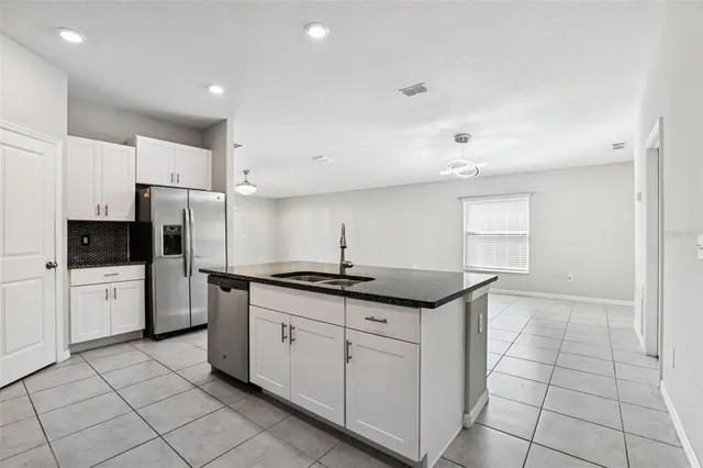 a kitchen with stainless steel appliances granite countertop a sink and a refrigerator
