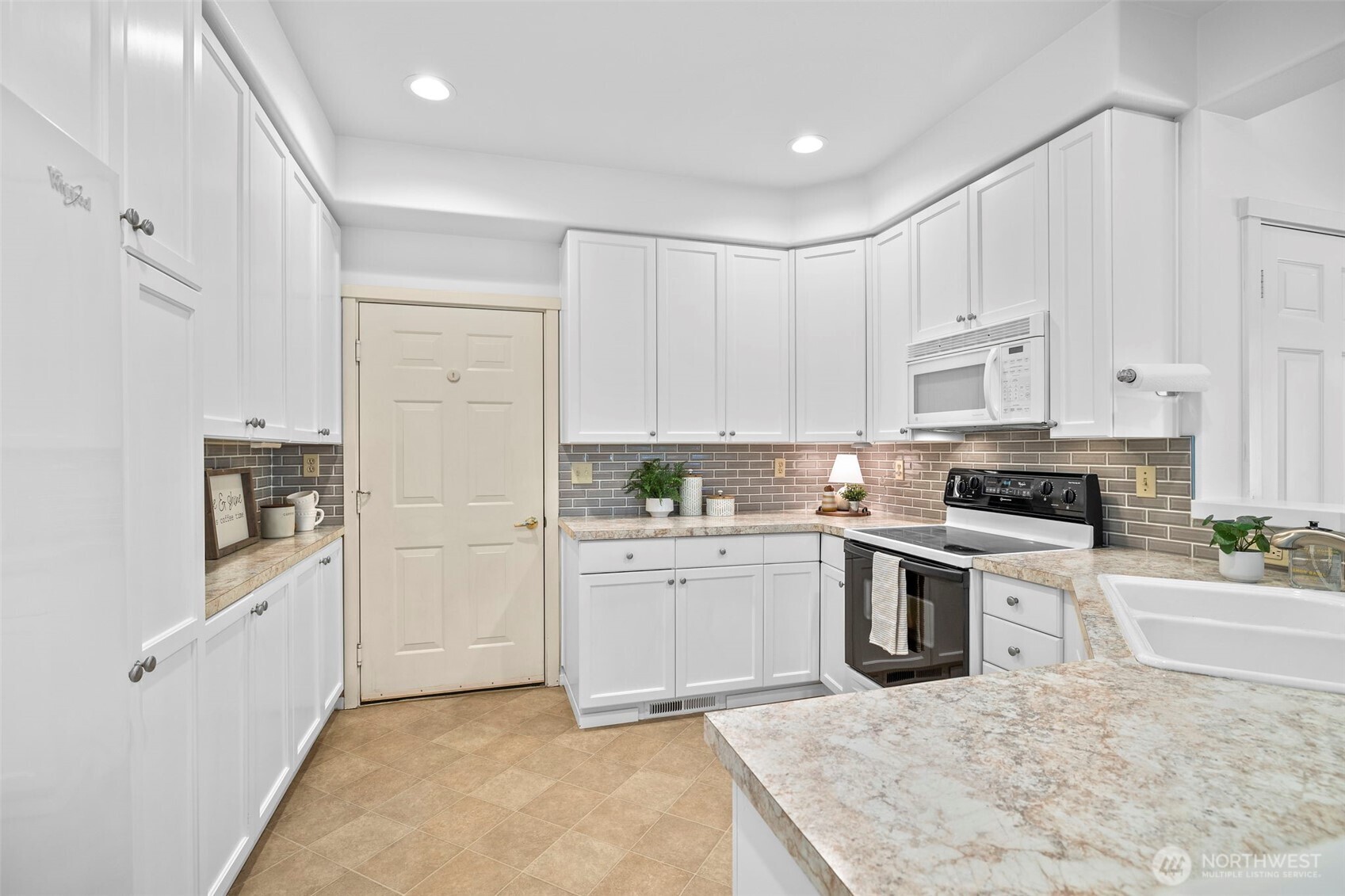 4310 Northeast 5th Court, Unit 101 Renton, WA 98059 - Photo 2 of 16 a kitchen with white cabinets and appliances