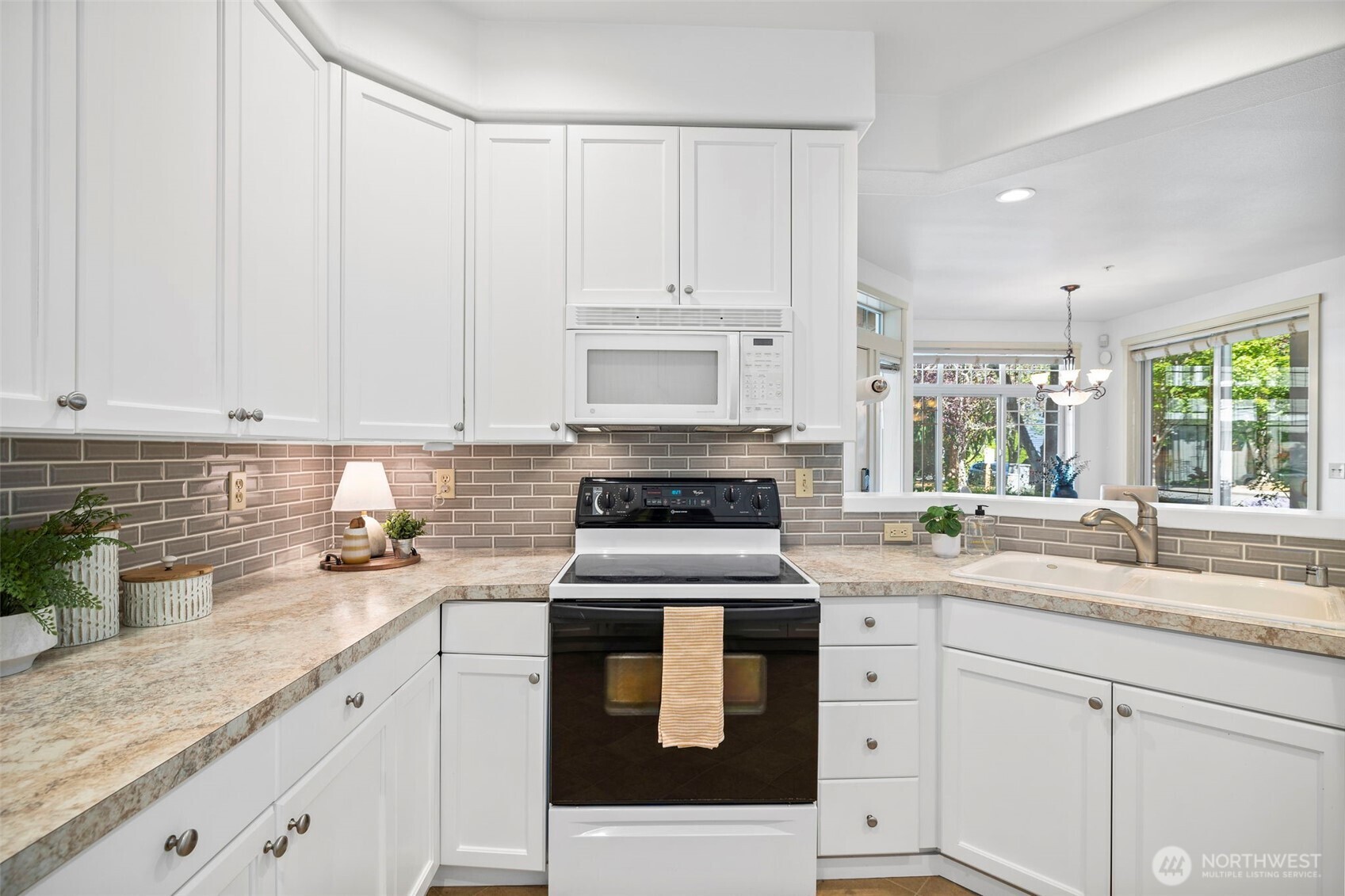 4310 Northeast 5th Court, Unit 101 Renton, WA 98059 - Photo 3 of 16 a kitchen with granite countertop white cabinets and white appliances