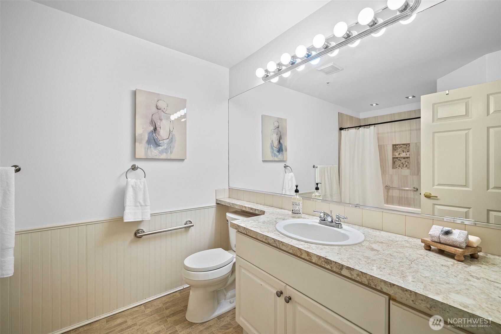 4310 Northeast 5th Court, Unit 101 Renton, WA 98059 - Photo 9 of 16 a bathroom with a toilet a sink and mirror