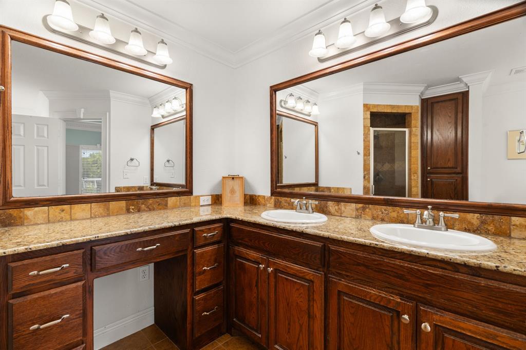 112 Waterfall Court Azle, TX 76020 - Photo 19 of 40 Double sinks and the separate dual-head shower is seen in the mirror.