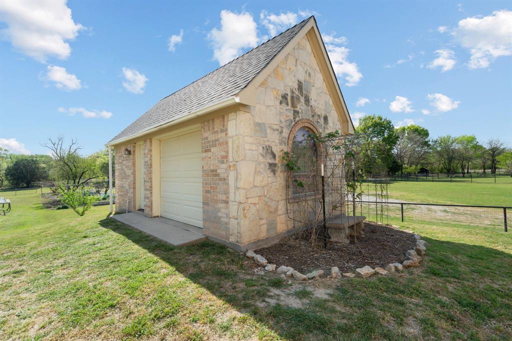 112 Waterfall Court Azle, TX 76020 - Photo 29 of 40 21 x 11 ft Workshop with roll up door to house all the yard equipment, play equipment or whatever you desire.