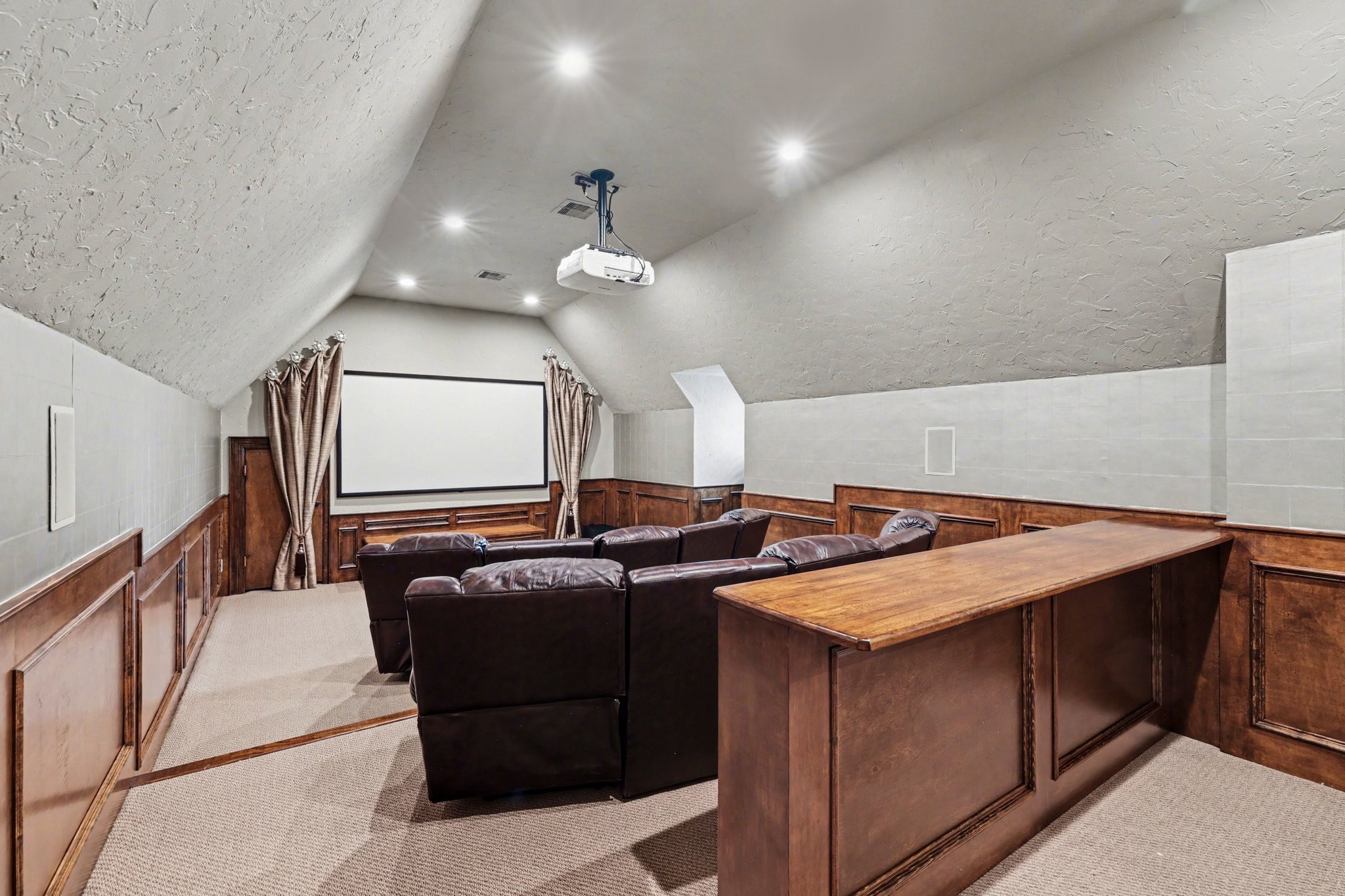 3 Player Ridge Court The Woodlands, TX 77382 - Photo 25 of 50 Dedicated home theater with elevated seating, projector setup, and a true cinematic feel. Behind the curtain is a massive storage closet.