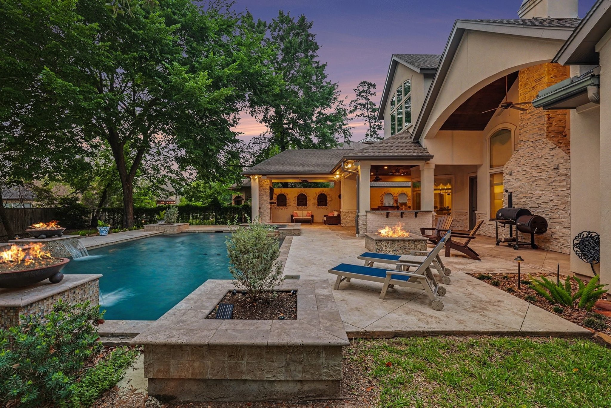 3 Player Ridge Court The Woodlands, TX 77382 - Photo 44 of 50 Incredible twilight setting highlighting the phenomenal pool, fire pit, and the outdoor kitchen.