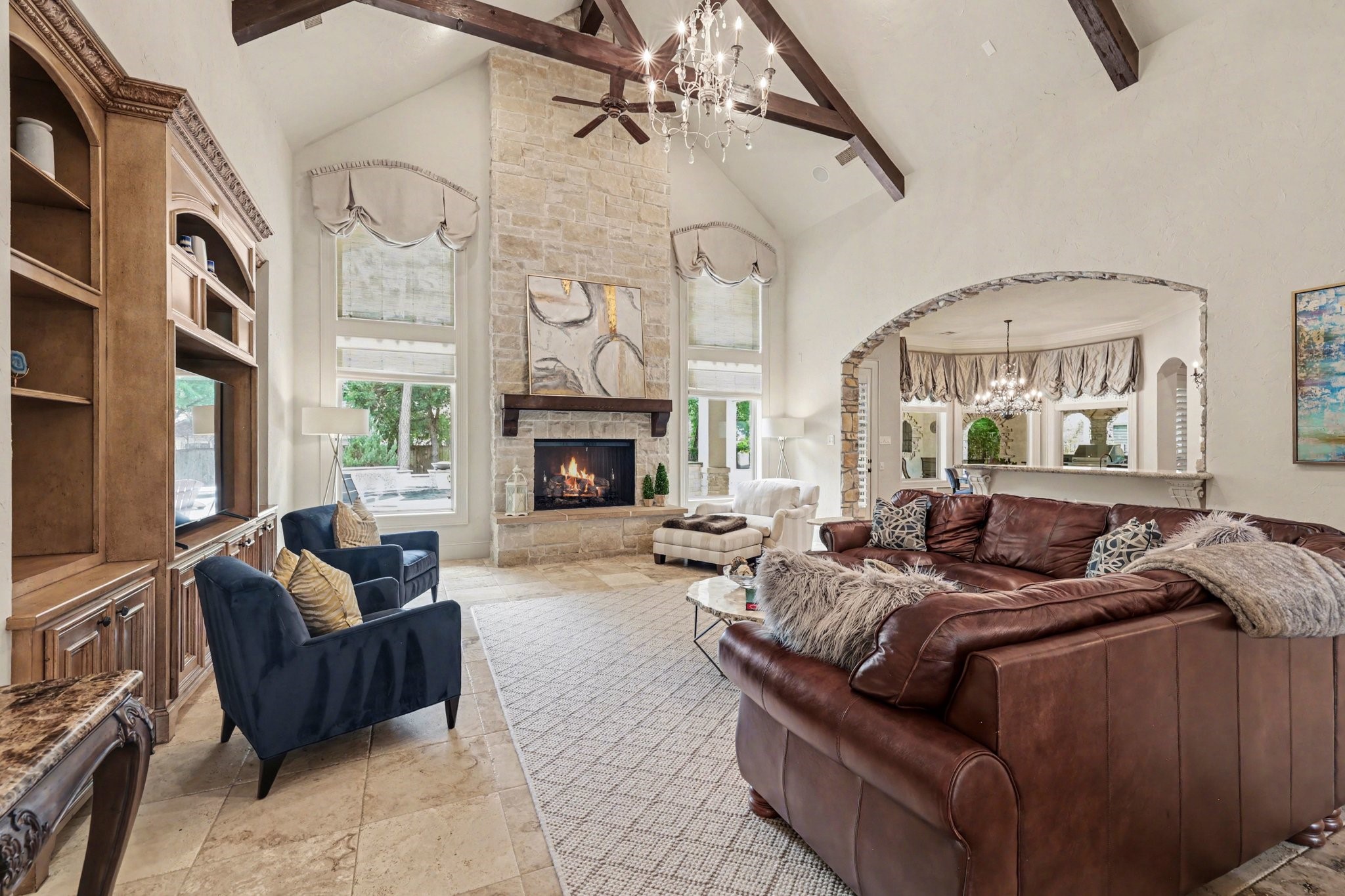 3 Player Ridge Court The Woodlands, TX 77382 - Photo 9 of 50 Impressive living room with dramatic ceilings, rich beam detail, and a statement fireplace.