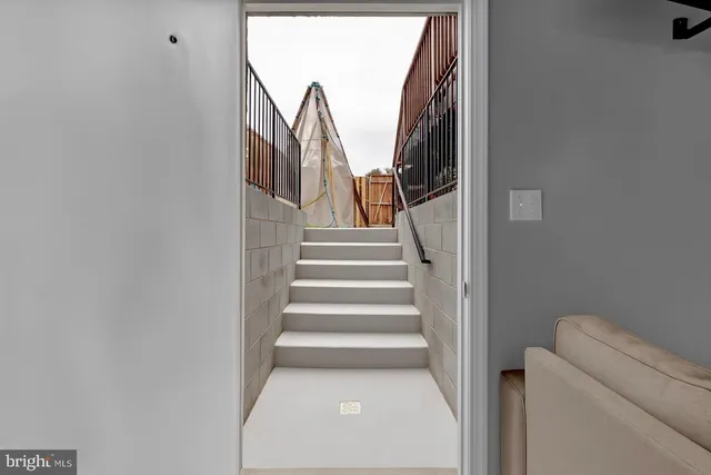 a view of a house with a barbeque and wooden stairs