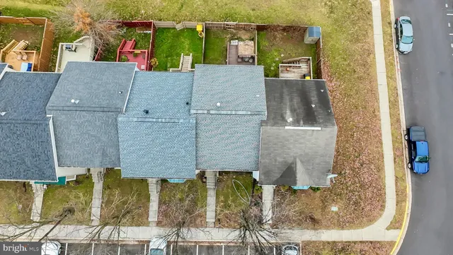 a view of a brick house with many windows plants and large tree