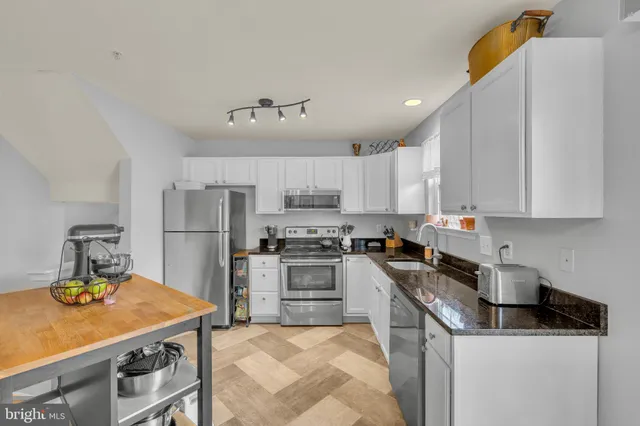 a kitchen with kitchen island a sink a stove and refrigerator