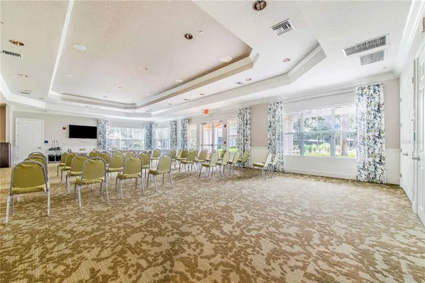 a living room with furniture a chandelier and a floor to ceiling window