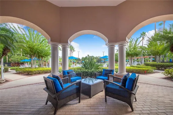 a view of a patio with table and chairs potted plants and palm tree