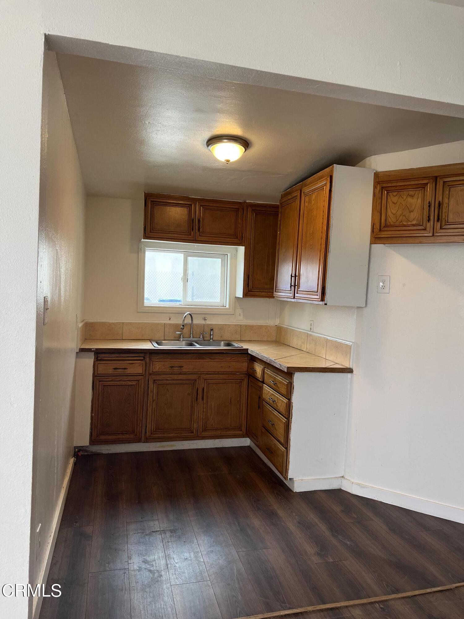 4840 Saviers Road Oxnard, CA 93033 - Photo 13 of 24 a kitchen with granite countertop white cabinets and white appliances