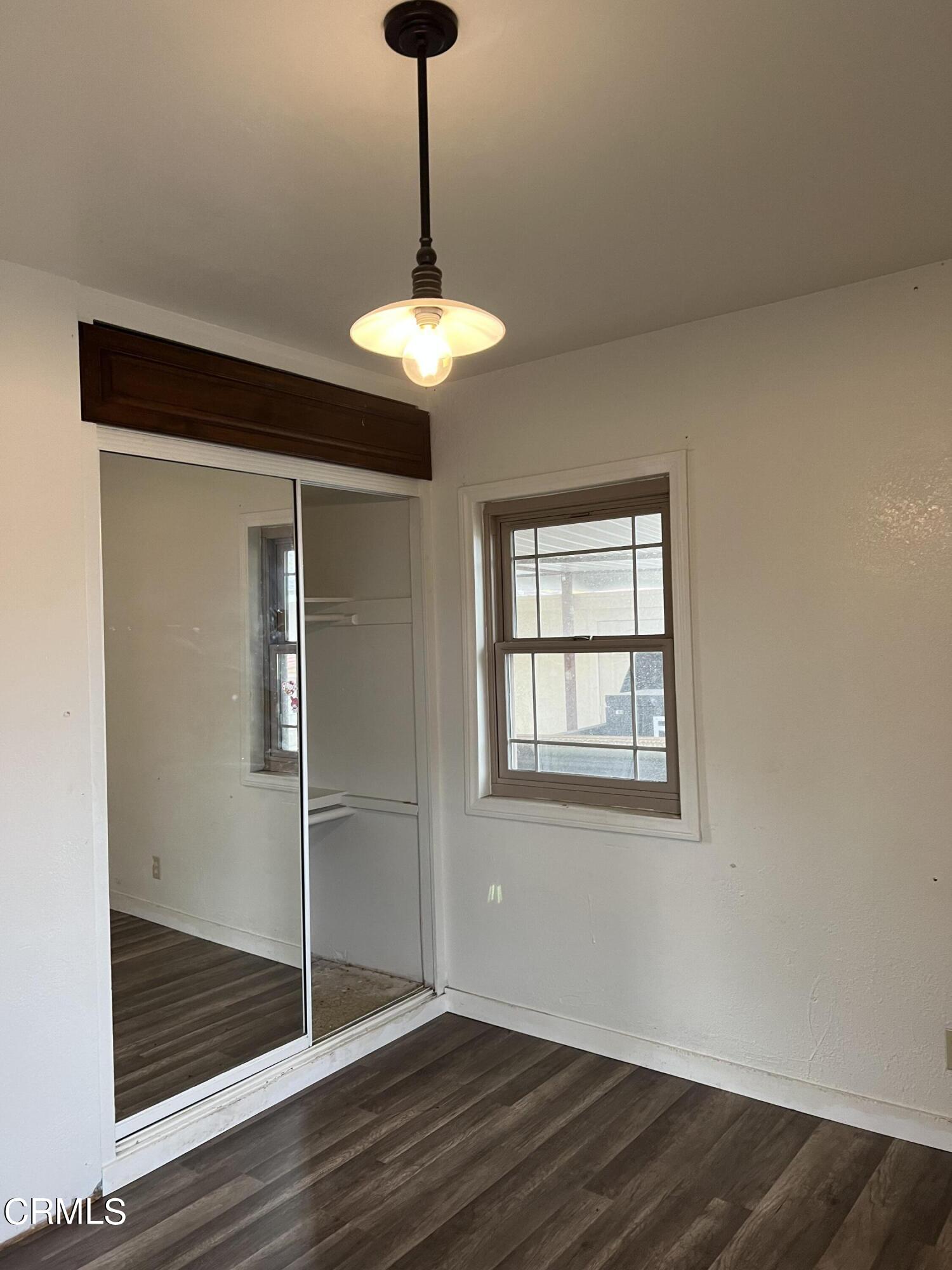 4840 Saviers Road Oxnard, CA 93033 - Photo 5 of 24 a view of an empty room with a window and wooden floor