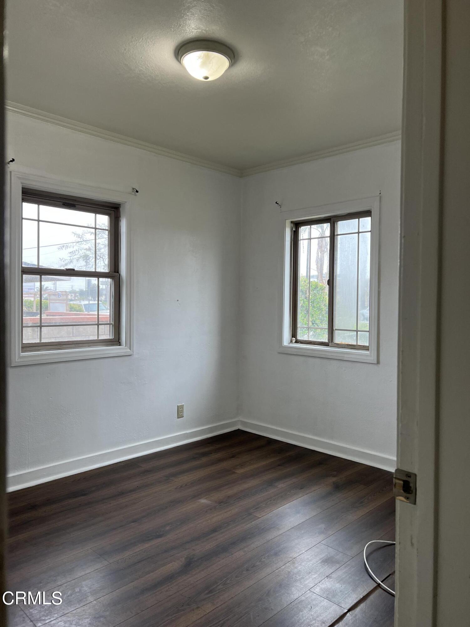 4840 Saviers Road Oxnard, CA 93033 - Photo 7 of 24 an empty room with wooden floor and windows