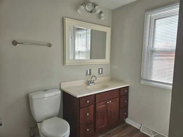 a bathroom with a toilet sink and mirror