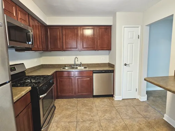 a kitchen with stainless steel appliances granite countertop a stove a sink and a microwave