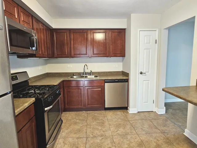 a kitchen with stainless steel appliances granite countertop a stove a sink and a microwave