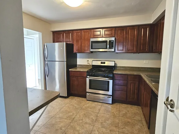 a kitchen with stainless steel appliances granite countertop a refrigerator stove and microwave