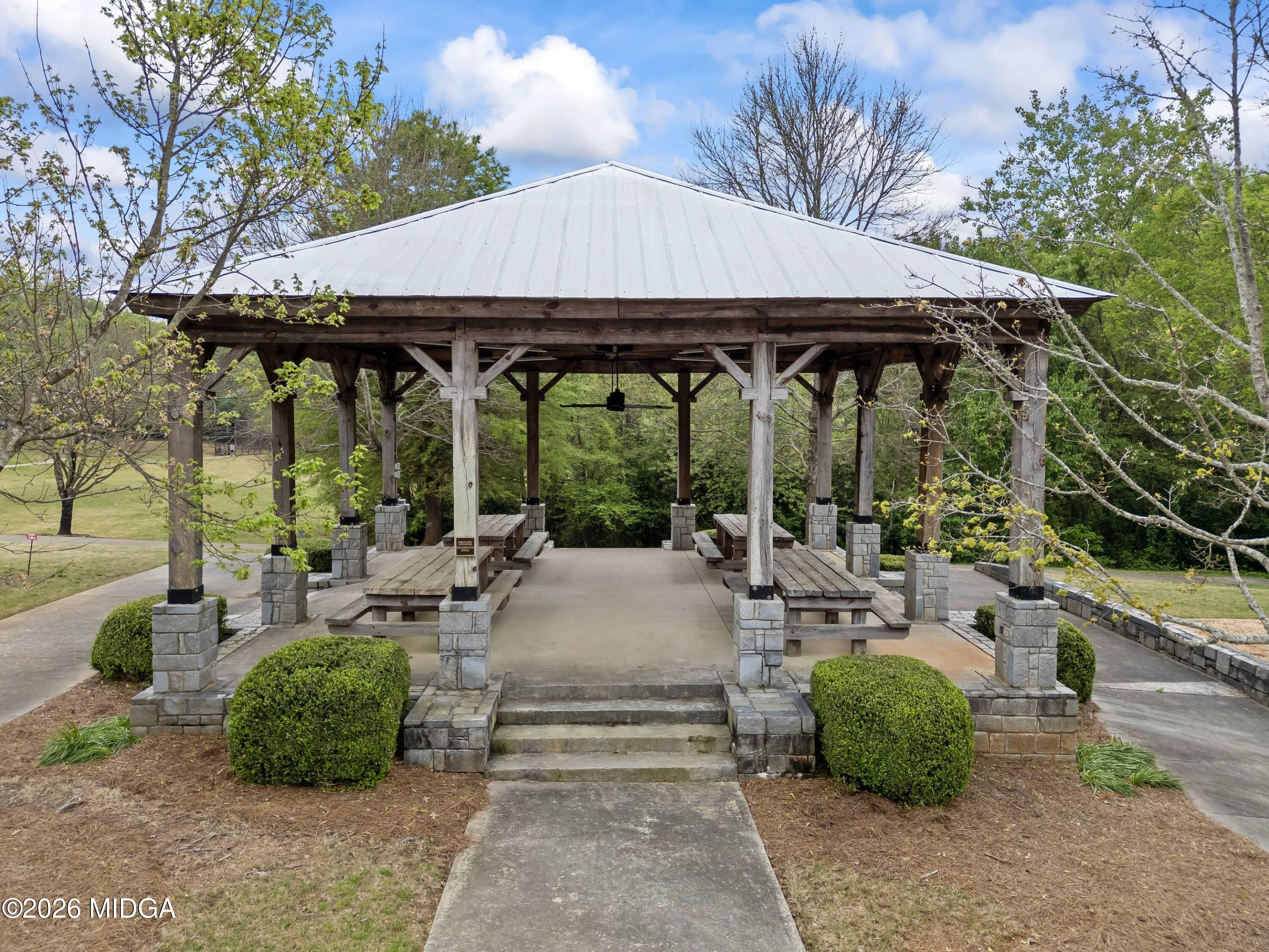 4121 North Swann Street Covington, GA 30014 - Photo 48 of 52 a view of a patio with table and chairs under an umbrella with large trees