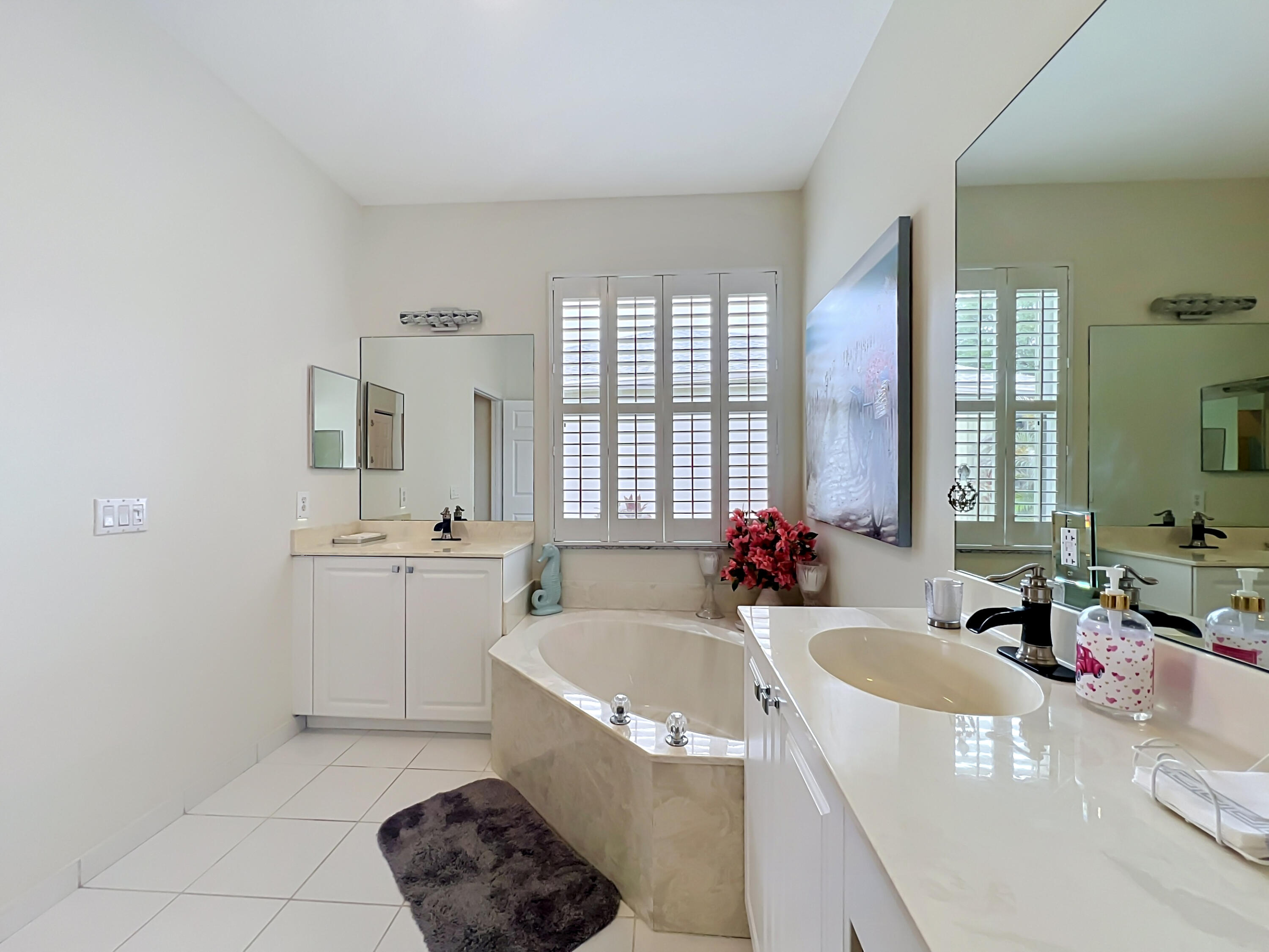 1343 Shoreline Circle Sebastian, FL 32958 - Photo 13 of 36 a bathroom with a tub a sink a mirror and a bathtub next to a window