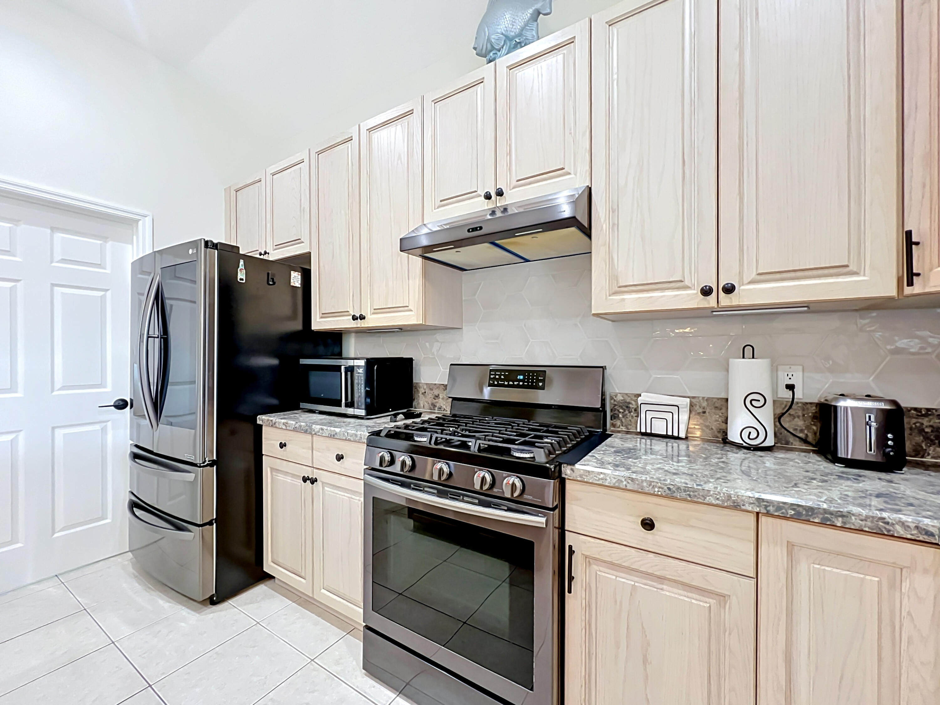1343 Shoreline Circle Sebastian, FL 32958 - Photo 19 of 36 a kitchen with stainless steel appliances granite countertop a refrigerator stove and white cabinets
