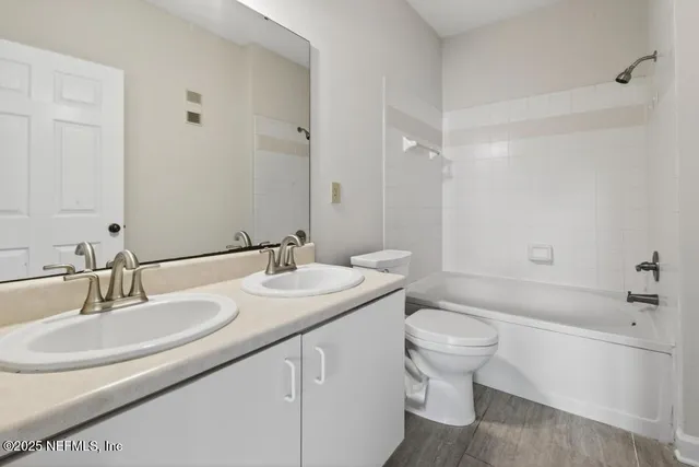 a bathroom with a granite countertop sink a toilet and a bathtub