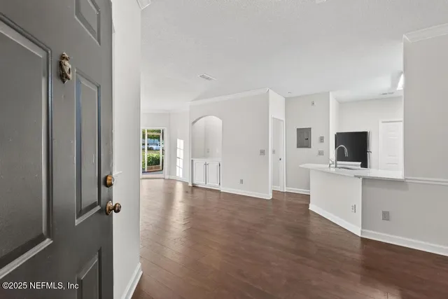 a view of a kitchen with a sink and a flat screen tv