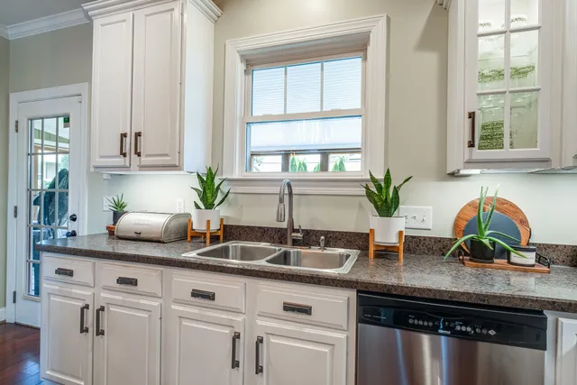 a kitchen with stainless steel appliances granite countertop a sink a counter space and windows